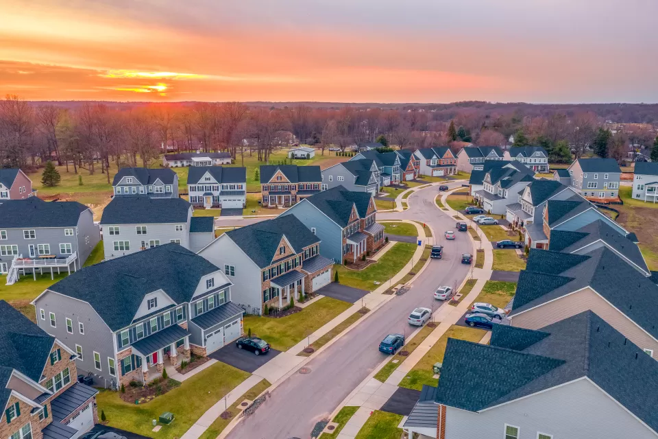 Large suburban homes on cul-de-sac in Maryland against sunset sky